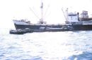 Sampans loading goods from a Ship, Singapore Harbour